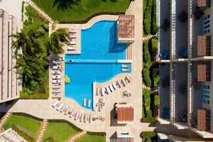 Espacio representativo del hotel: Vista aérea de una piscina rodeada de asientos con tumbonas.