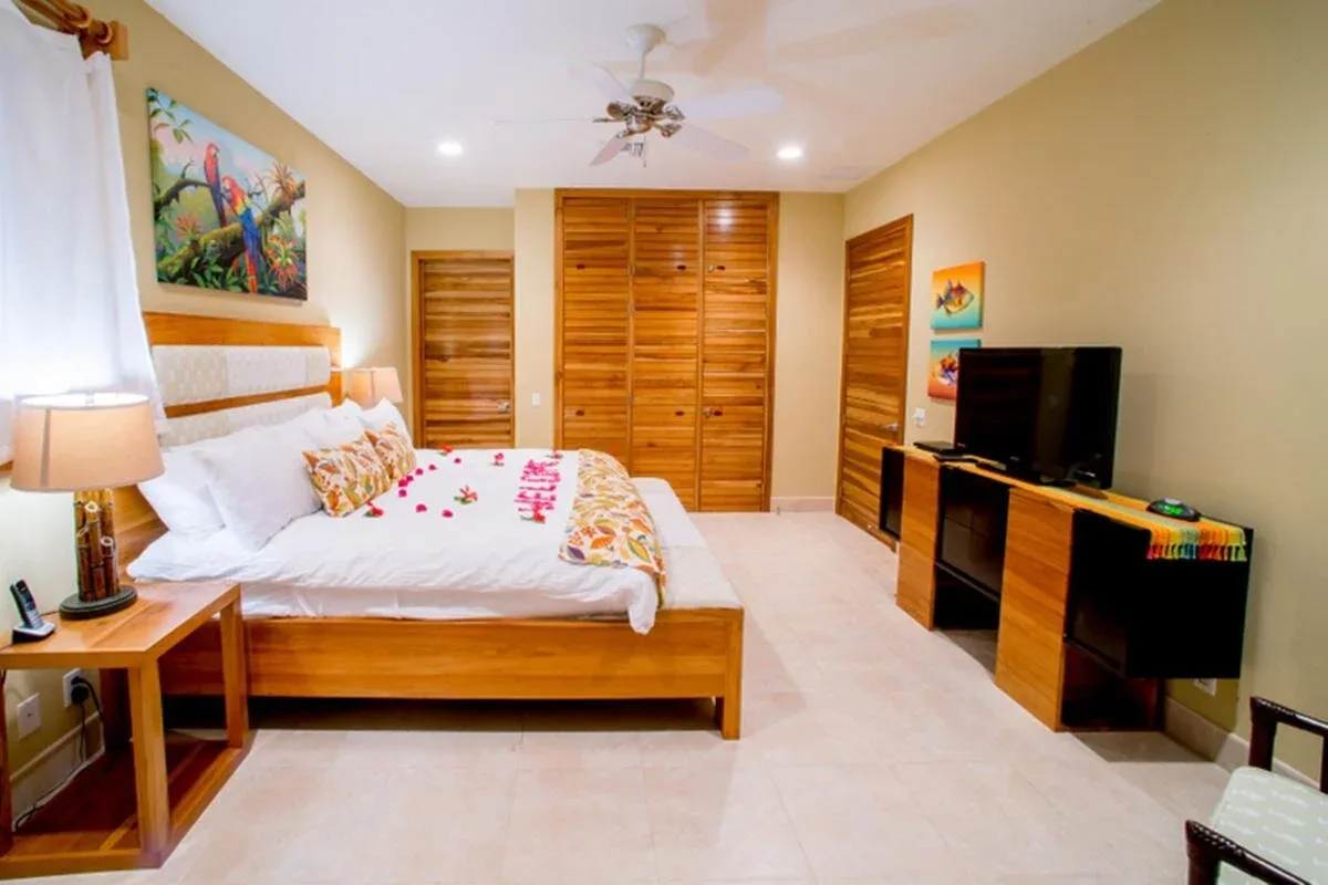 Espacio representativo del hotel: Un dormitorio con una cama, armarios de madera y un televisor.