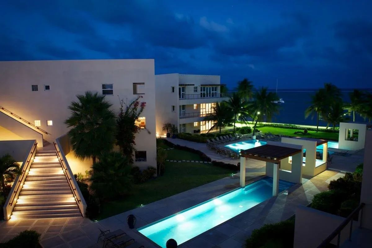 Espacio representativo del hotel: Un patio de resort por la noche cuenta con piscinas iluminadas y edificios modernos.