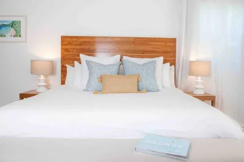 Espacio representativo del hotel: Un dormitorio con una cama bien tendida y un cabecero de madera.