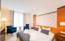 Representative hotel space: A hotel bedroom with a bed, armchair, and window.