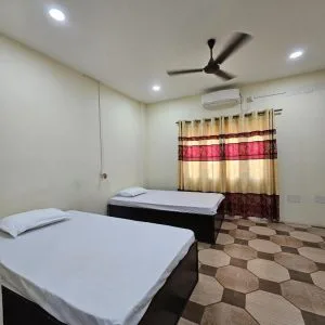 Espacio representativo del hotel: Una habitación con dos camas, una ventana con cortinas y un ventilador de techo.