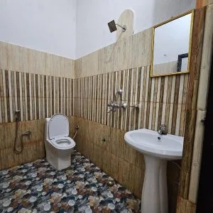Espacio representativo del hotel: Un baño con azulejos, inodoro y lavabo con pedestal.
