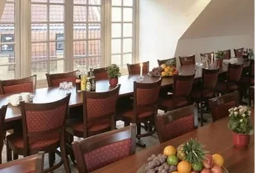 Representative hotel space: A dining area with tables, chairs, and large windows.
