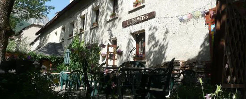 Representative hotel space: A stone building with outdoor seating and plants beside the entrance.