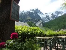 Representative hotel space: An outdoor dining area overlooks green hills and snow-capped mountains.