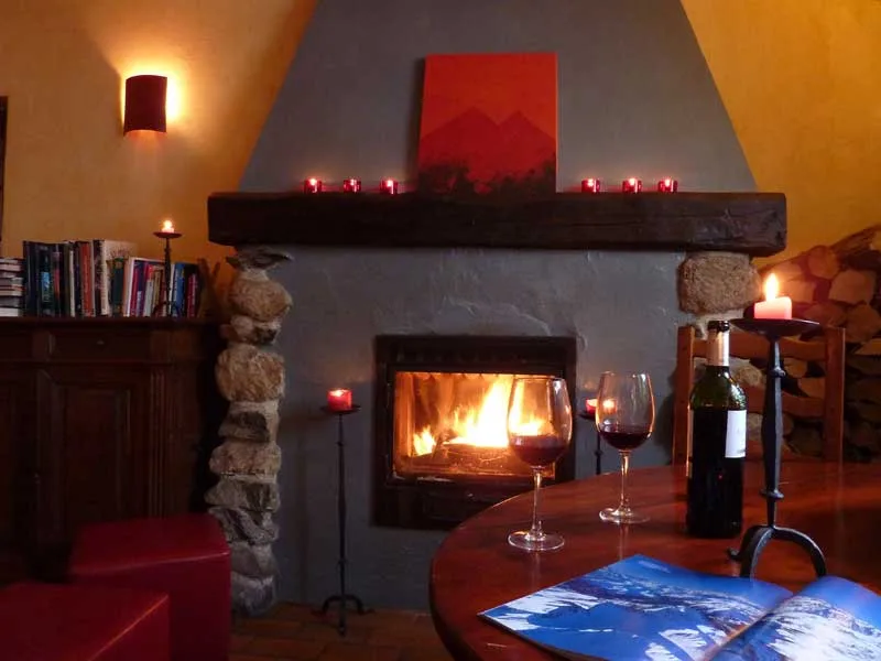 Representative hotel space: A warmly lit living room features a glowing fireplace and a round table.