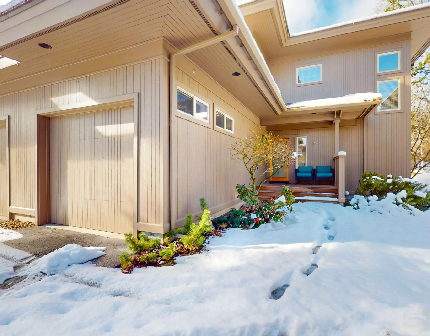 Zona común: La nieve cubre la entrada exterior de una casa con un porche techado.
