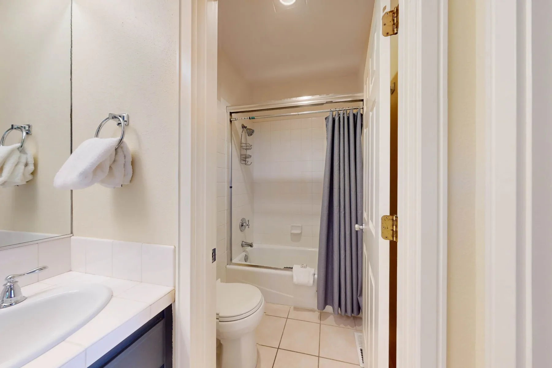 Se ven un lavabo y un inodoro junto a una bañera con cortina de ducha.