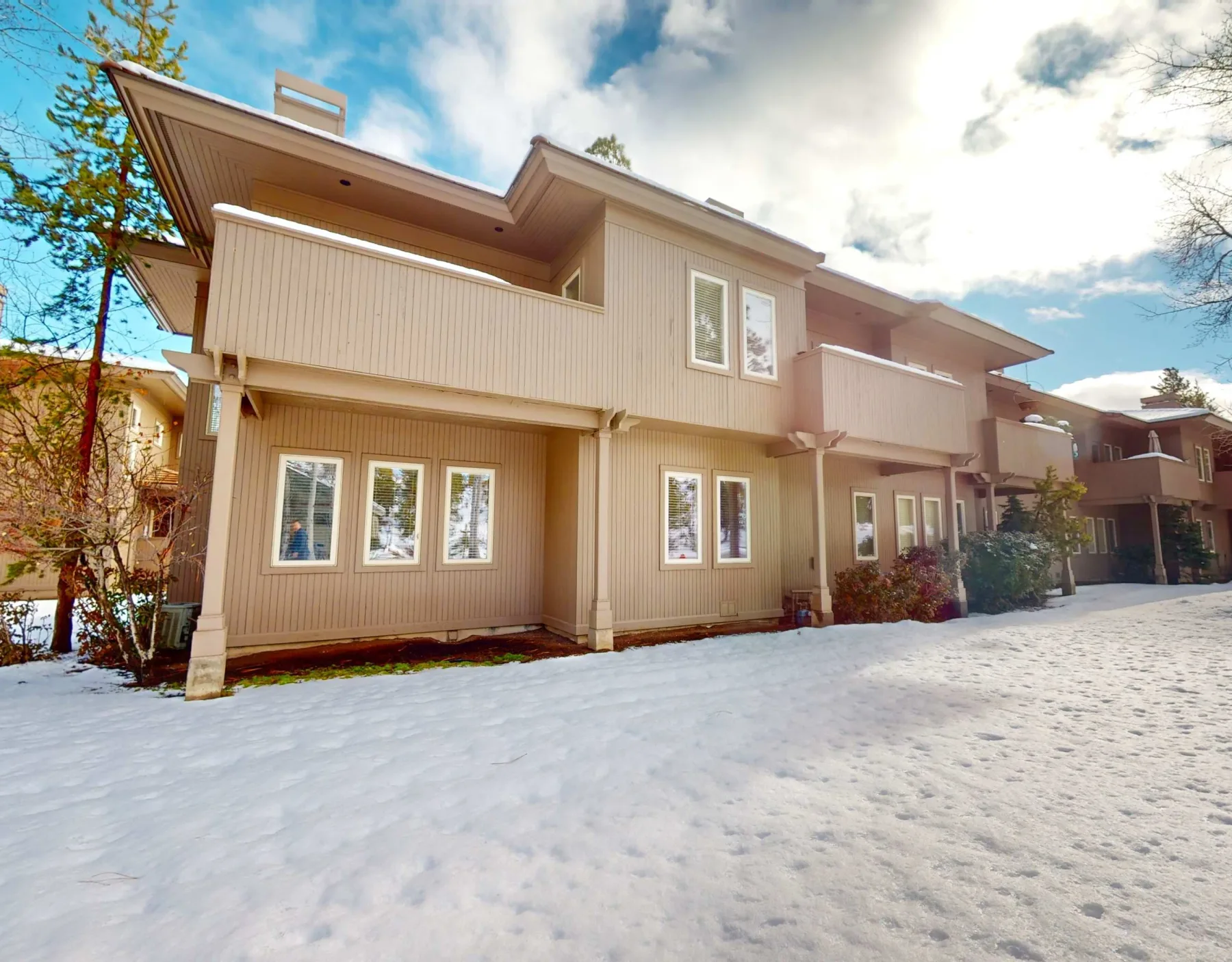 Zona común: Una fila de edificios de apartamentos color beige junto a un patio cubierto de nieve.