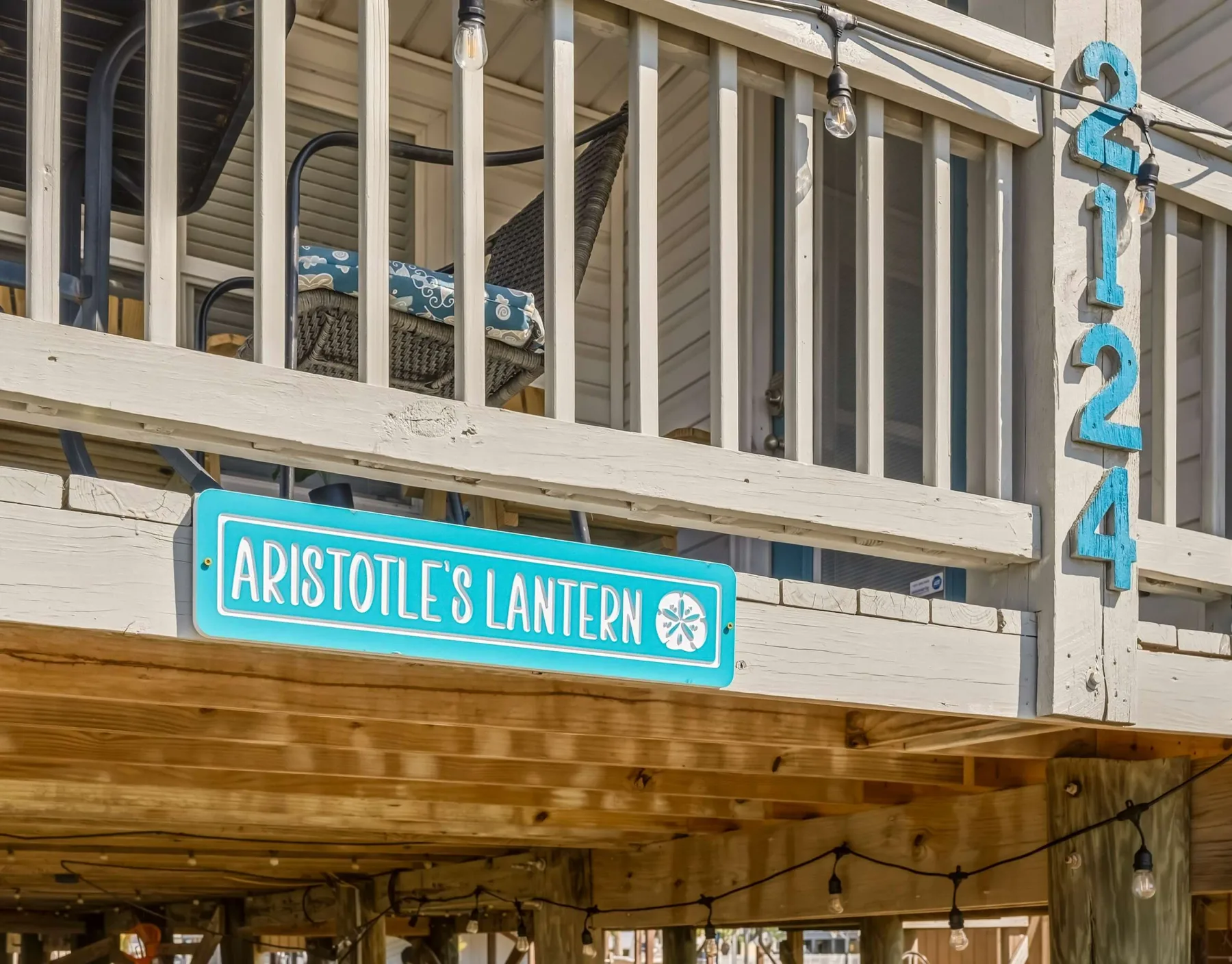 A wooden building exterior with a turquoise sign reading “Aristotle’s Lantern.”