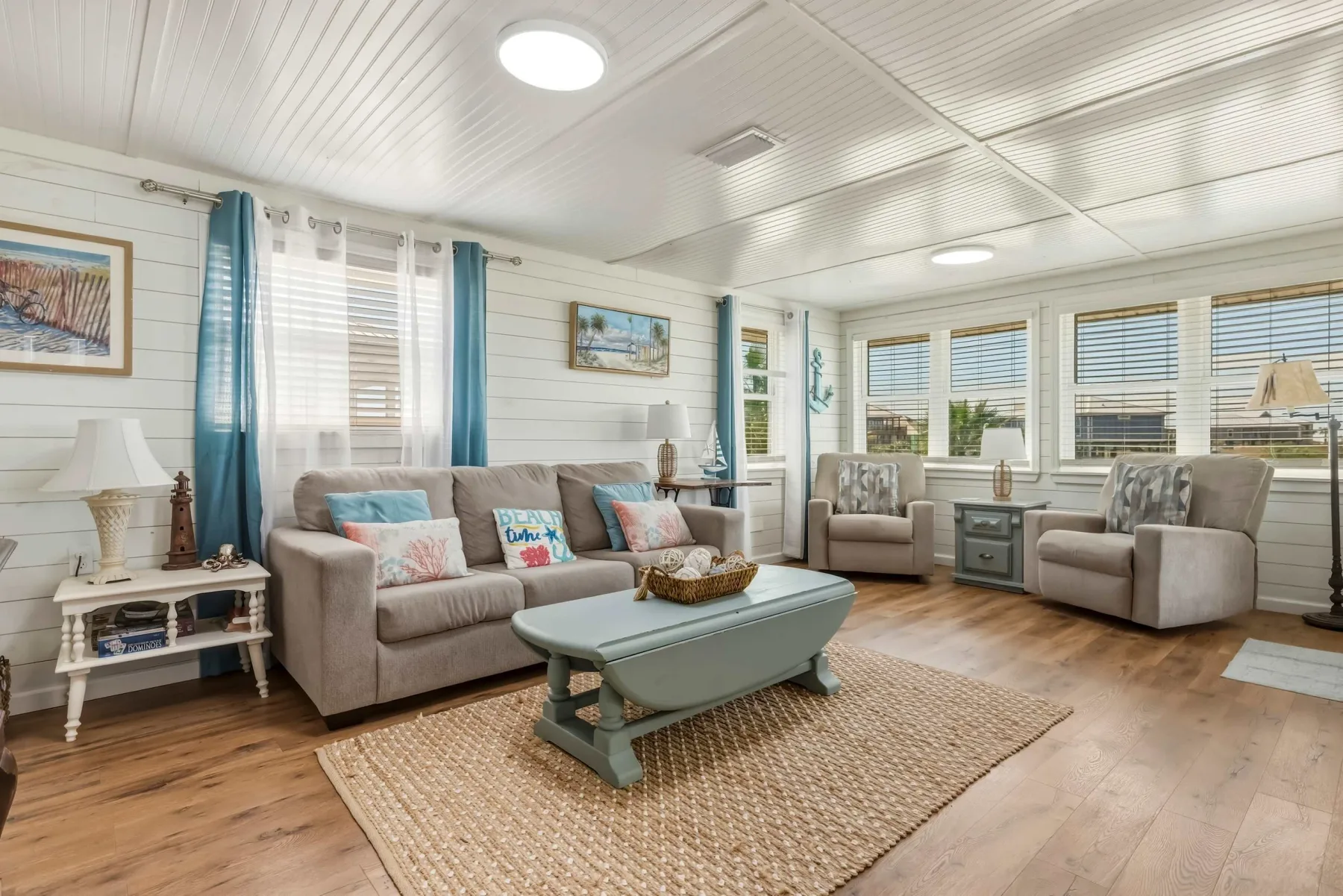 A bright living room with seating around a coffee table and large windows.