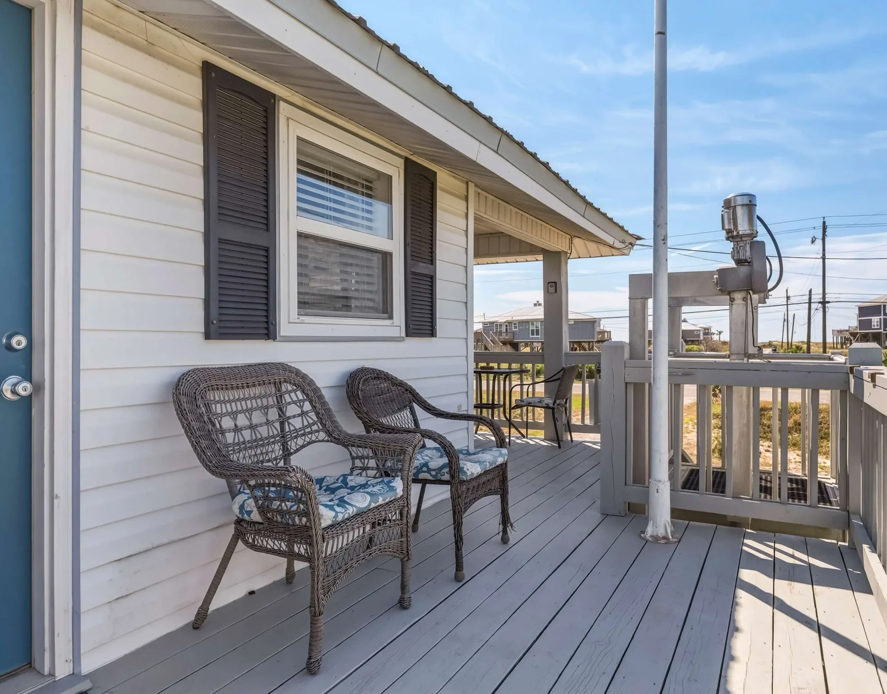 A covered porch with seating and a railing overlooks the surrounding area.