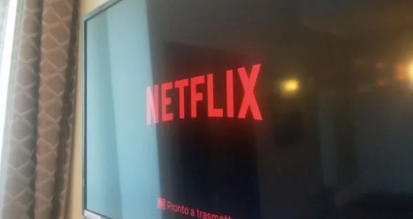 Espacio representativo del hotel: Un televisor muestra el logotipo de Netflix junto a una cortina estampada.