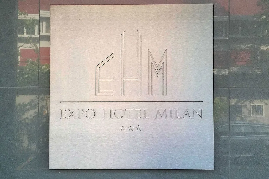 Espacio representativo del hotel: Rótulo de hotel montado sobre una fachada de vidrio reflectante.