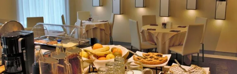 Espacio representativo del hotel: Un comedor con platos de desayuno dispuestos en un mostrador de buffet.