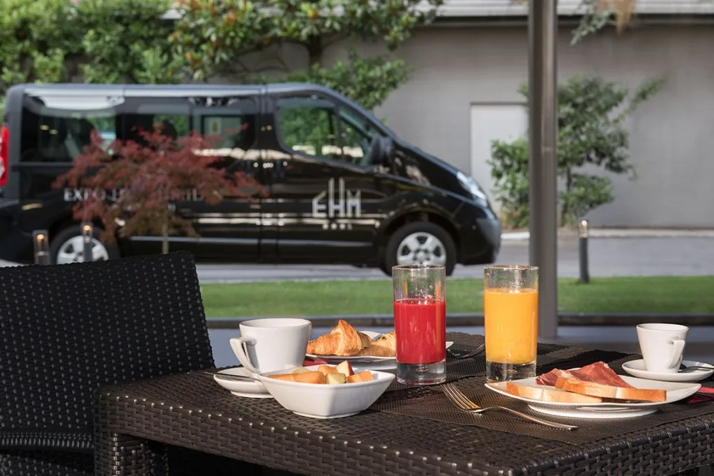 Espacio representativo del hotel: Una mesa de desayuno con bollería, fruta y vasos de zumo.
