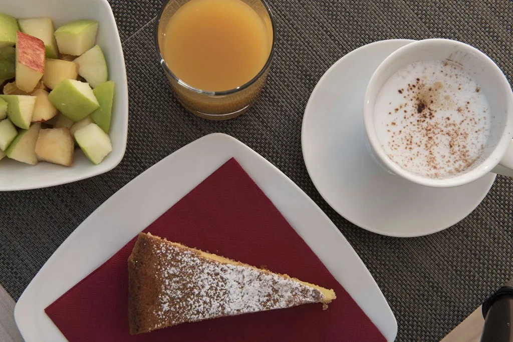 Espacio representativo del hotel: Un desayuno con fruta, jugo, café y una porción de pastel.