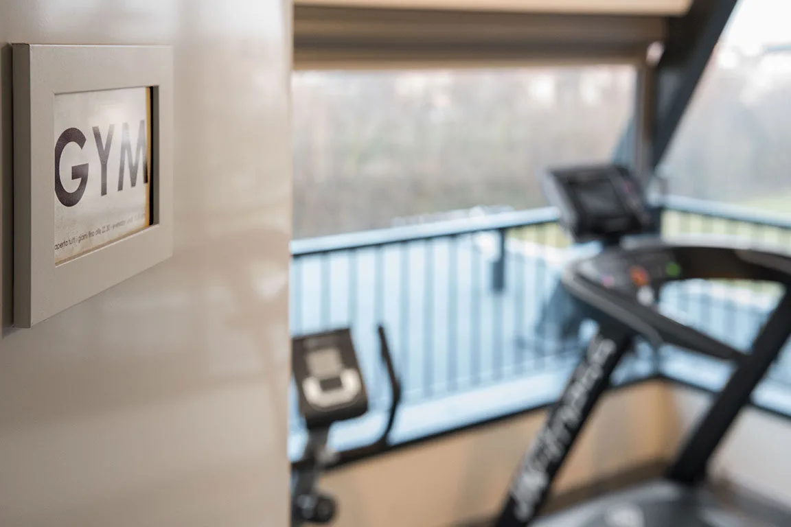 Espacio representativo del hotel: Un gimnasio con equipo de ejercicio junto a una ventana grande.