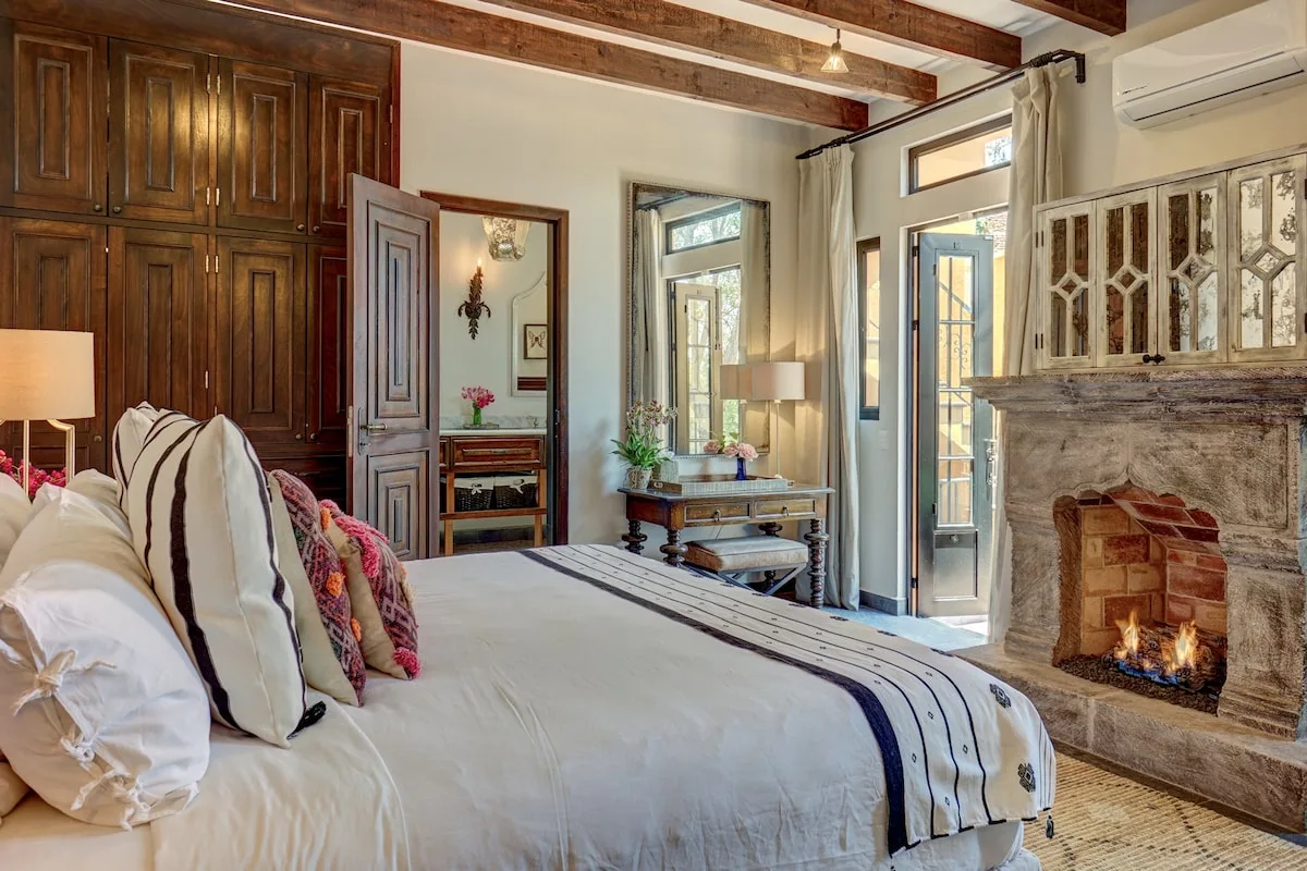 Un dormitorio con una cama grande, muebles de madera oscura y una chimenea.