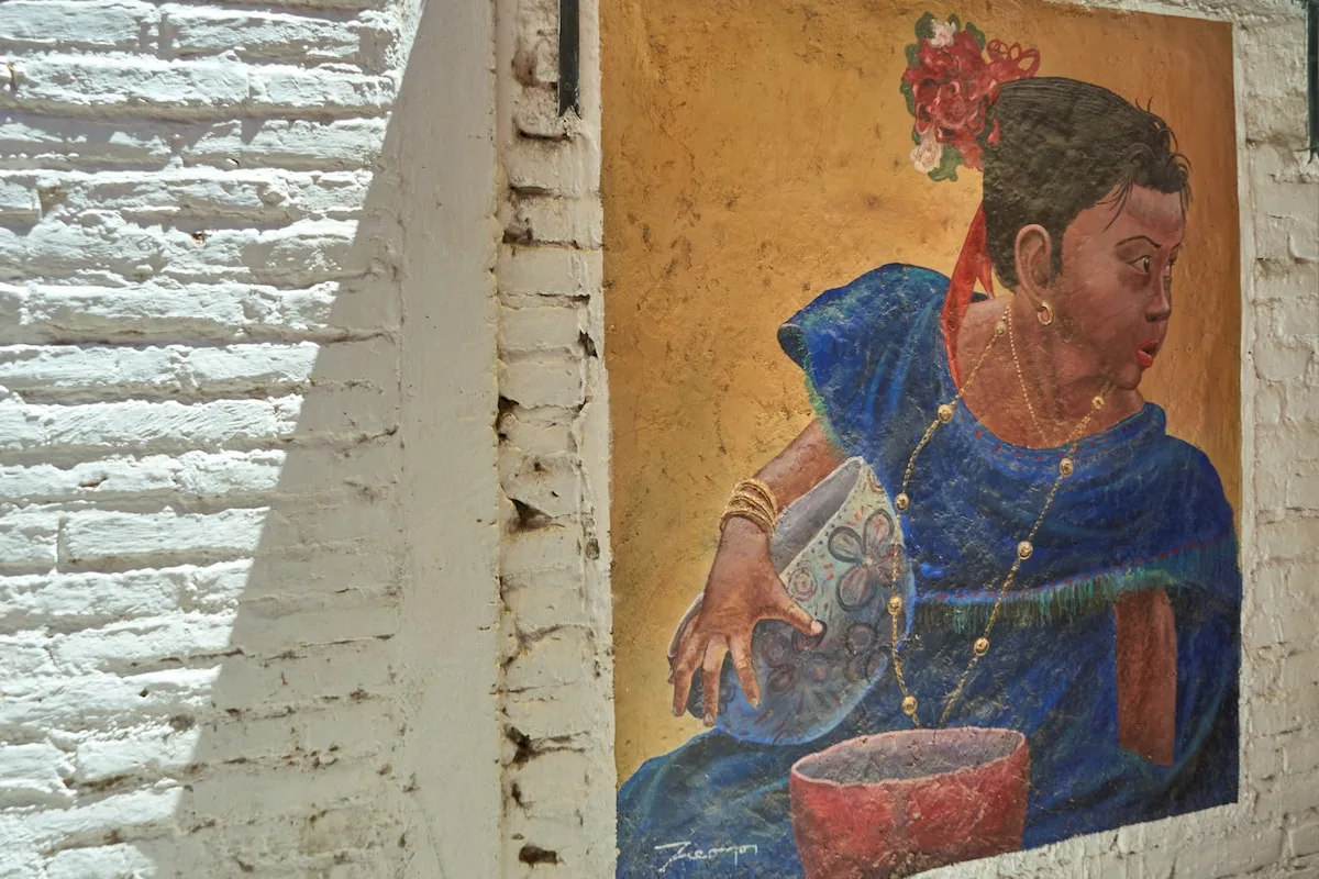 Un mural colorido muestra a una mujer de azul sosteniendo un objeto estampado.