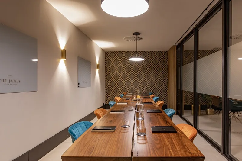 Representative hotel space: A meeting room with a long wooden table and patterned walls.
