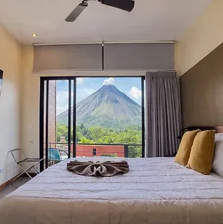 Representative hotel space: A bedroom with a bed facing sliding glass doors and a mountain view.