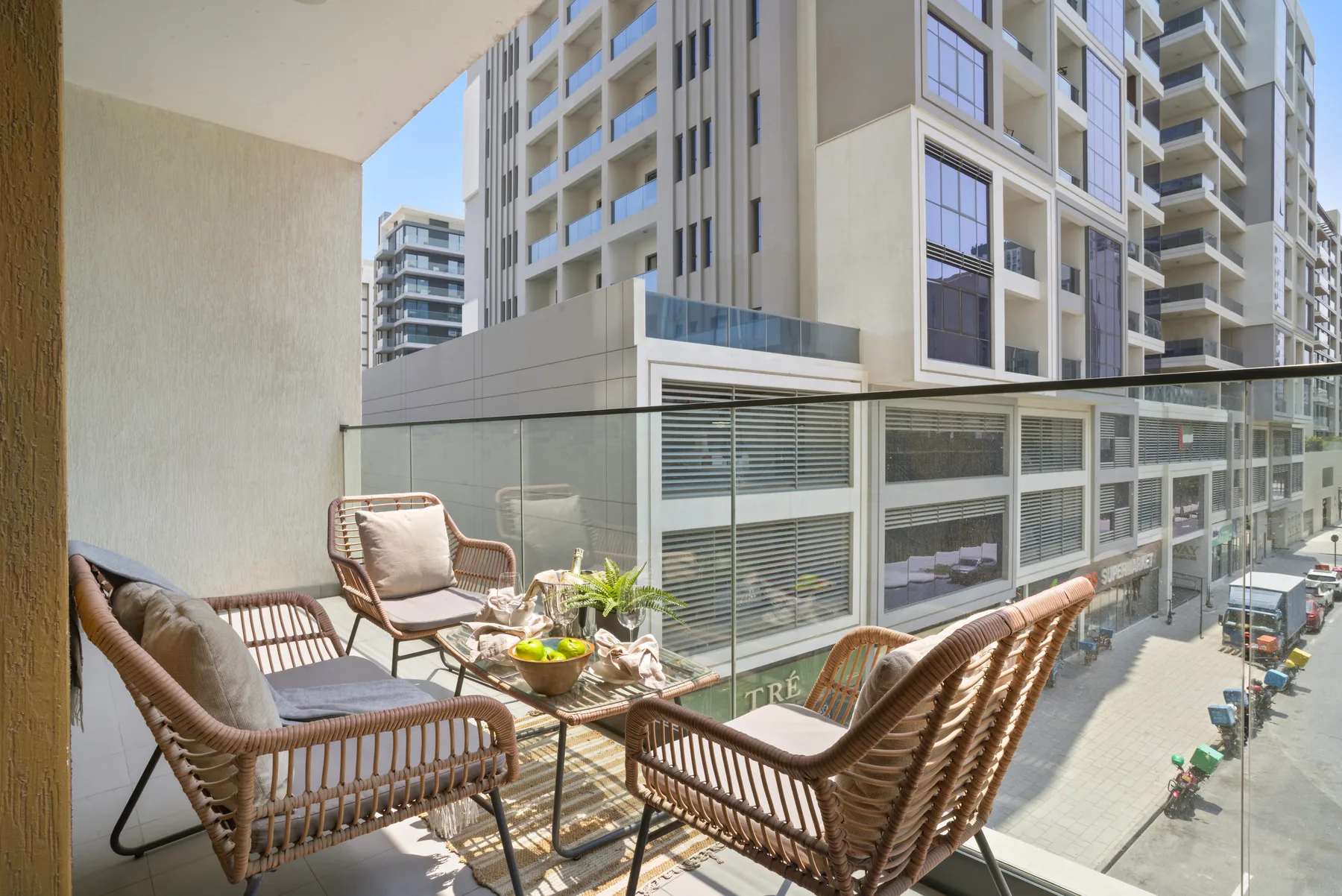A balcony seating area overlooks nearby high-rise buildings.
