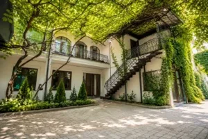 Representative hotel space: A leafy courtyard with a paved patio and an exterior staircase.
