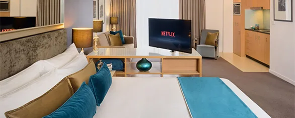Representative hotel space: A hotel room with a bed, seating area, and television.