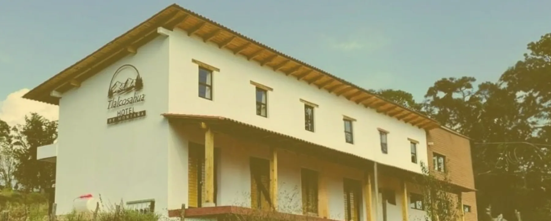 Espacio representativo del hotel: Edificio alargado de poca altura, con paredes blancas y techo inclinado.