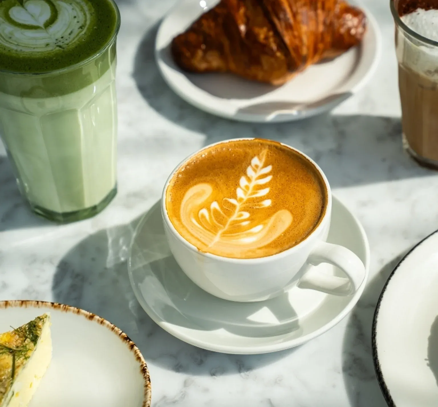 Representative hotel space: Coffee drinks and a pastry are arranged on a marble table.