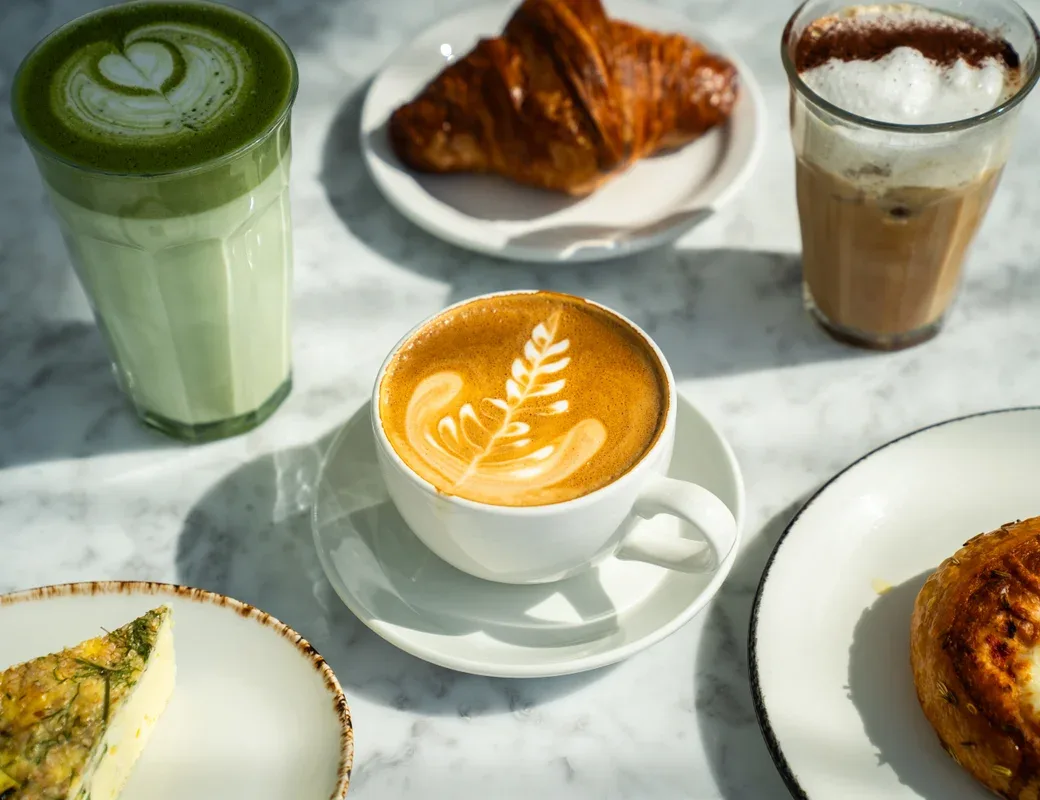 Representative hotel space: Coffee drinks and pastries are arranged on a marble tabletop.