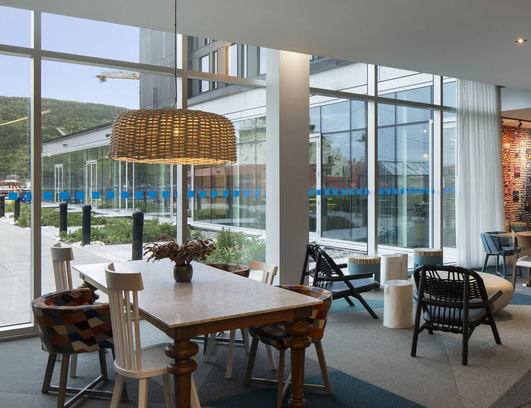 Representative hotel space: A modern interior seating and dining area beside floor-to-ceiling windows.