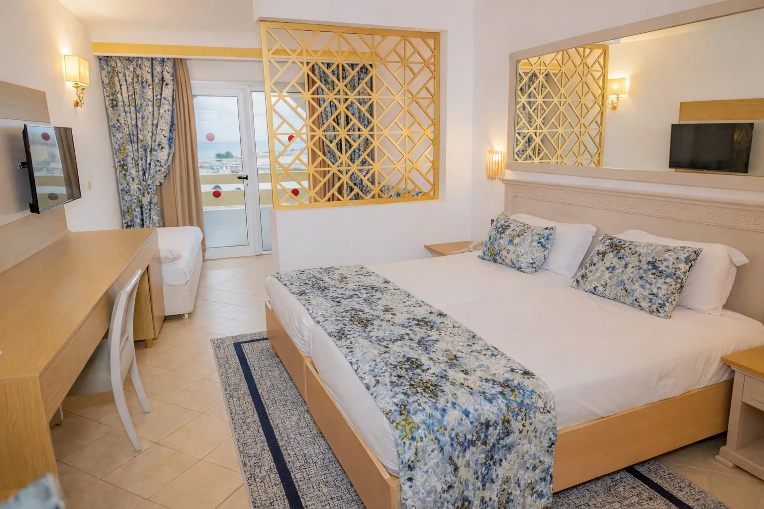 Espacio representativo del hotel: Un dormitorio de hotel con cama, escritorio y paneles de celosía estampados.