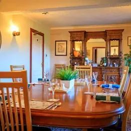 Representative hotel space: A dining room with a long wooden table and chairs.