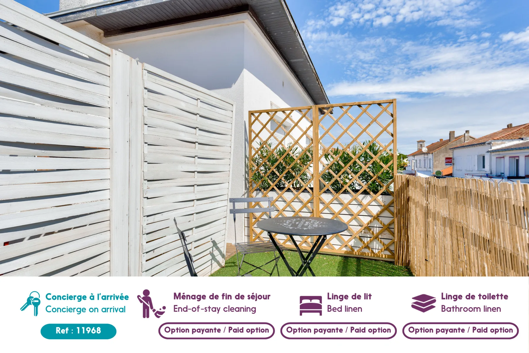 An outdoor patio with a small table, lattice screen, and privacy fencing.