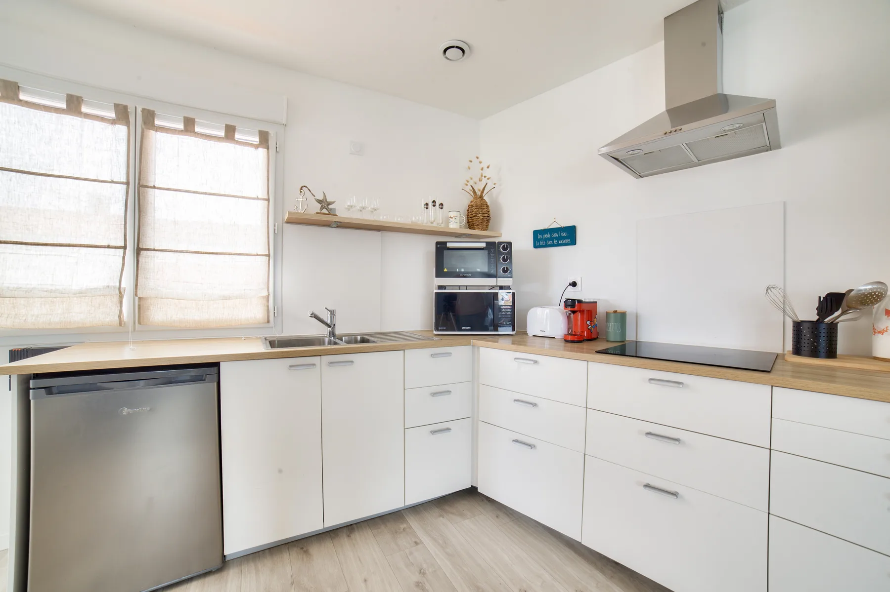 A bright kitchen with white cabinets, a countertop, and a window.