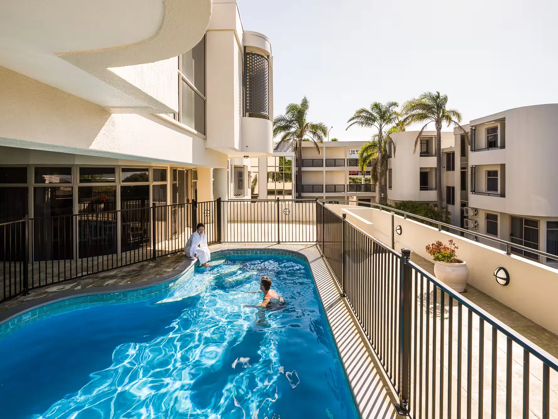 Representative hotel space: An outdoor hotel pool sits beside a modern building courtyard.