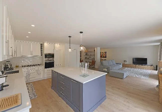 An open-plan kitchen and living area with a central island and seating.