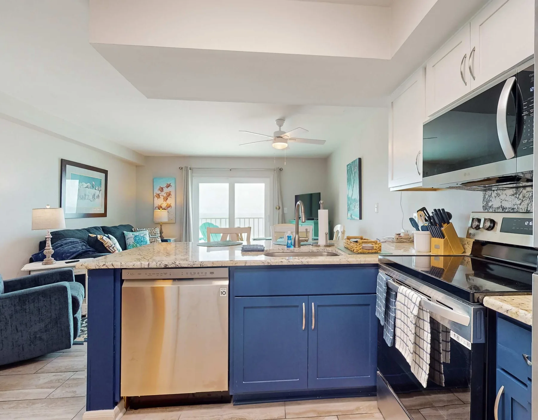 Cocina y sala de estar de concepto abierto con gabinetes azules y asientos.