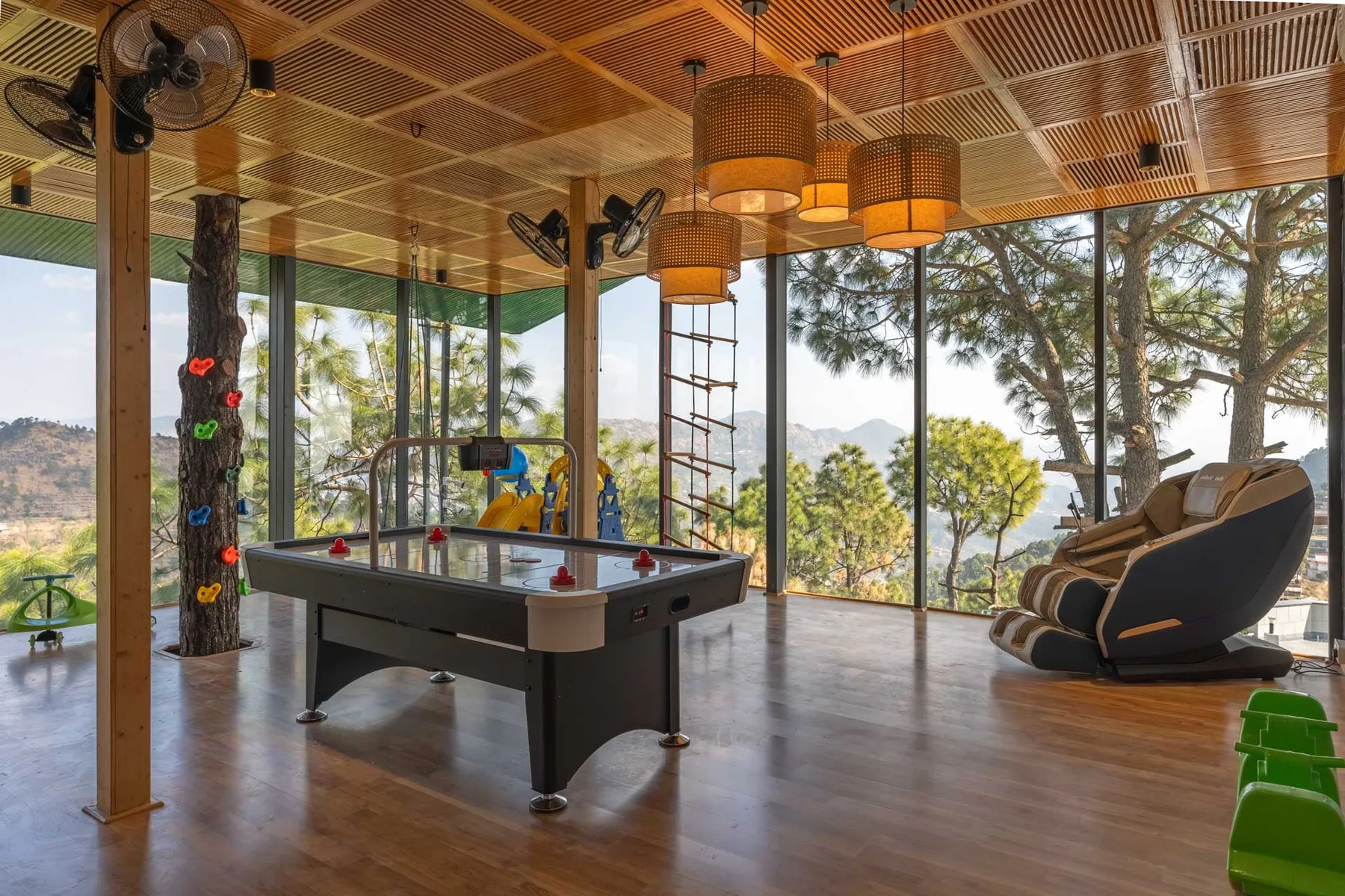 A recreation room features a pool table, climbing wall, and lounge seating.