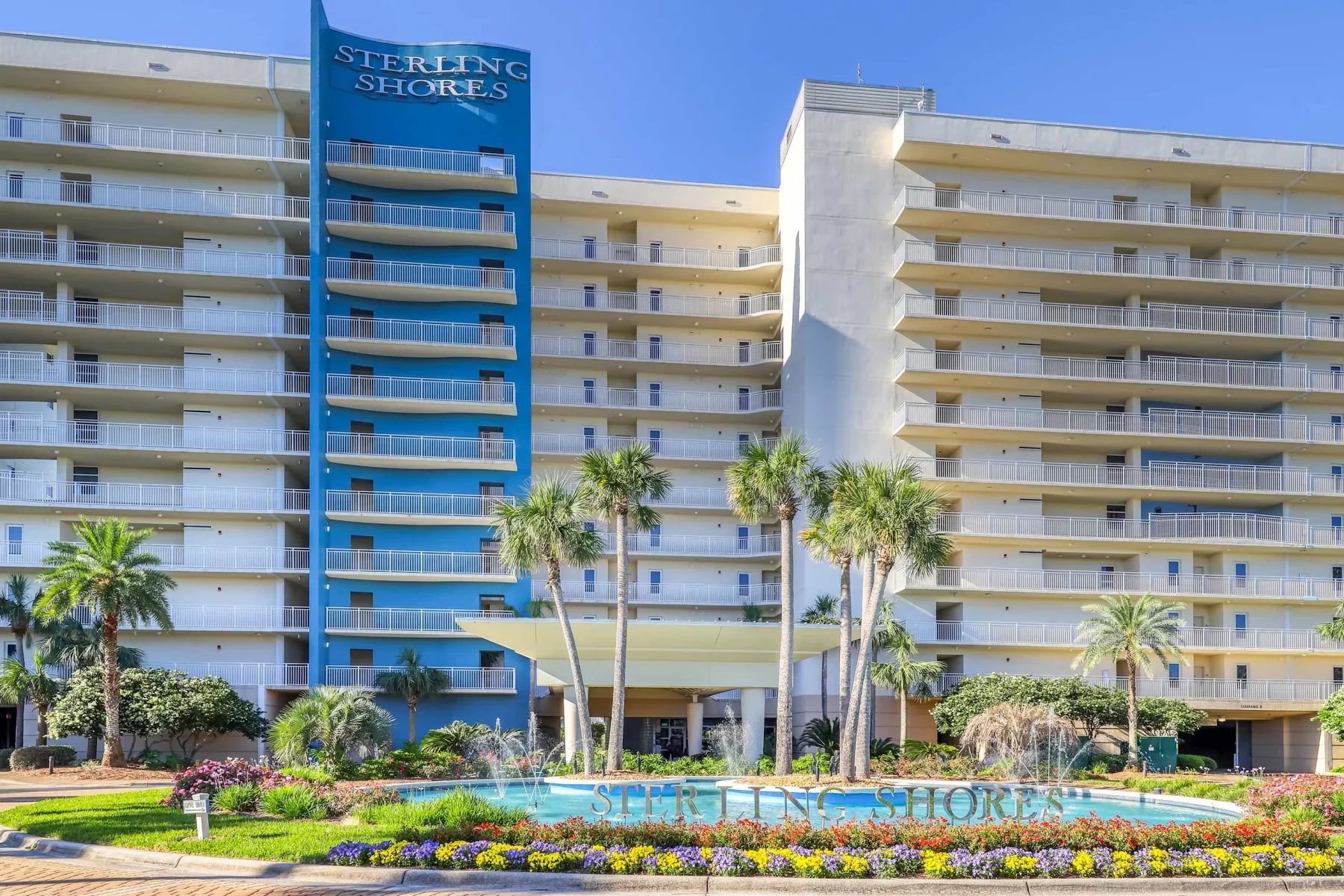 Zona común: La fachada de un hotel con balcones, palmeras y jardines.