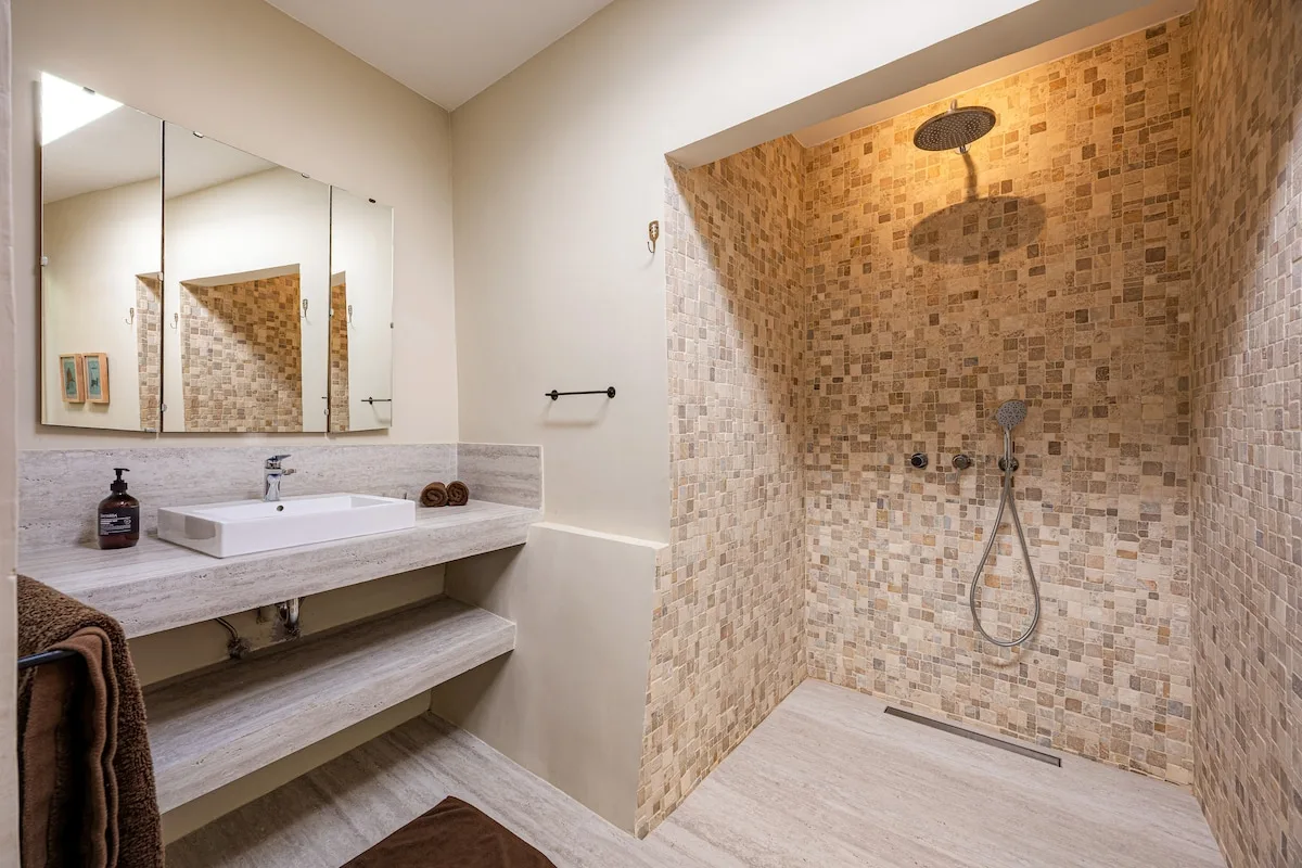 A bathroom with a wide vanity and a tiled shower area.