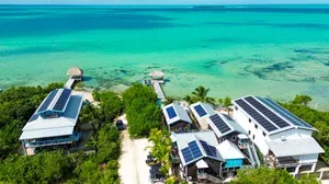 Espacio representativo del hotel: Vista aérea de edificios junto al agua turquesa y la vegetación verde.