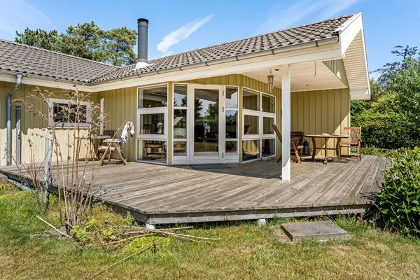 A house patio with a broad wooden deck and large windows.