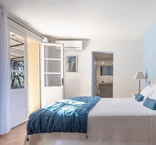 Representative hotel space: A bedroom with a bed beside a bright window.