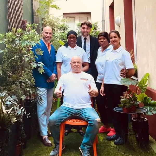 Representative hotel space: A group of people poses together in a plant-lined courtyard.