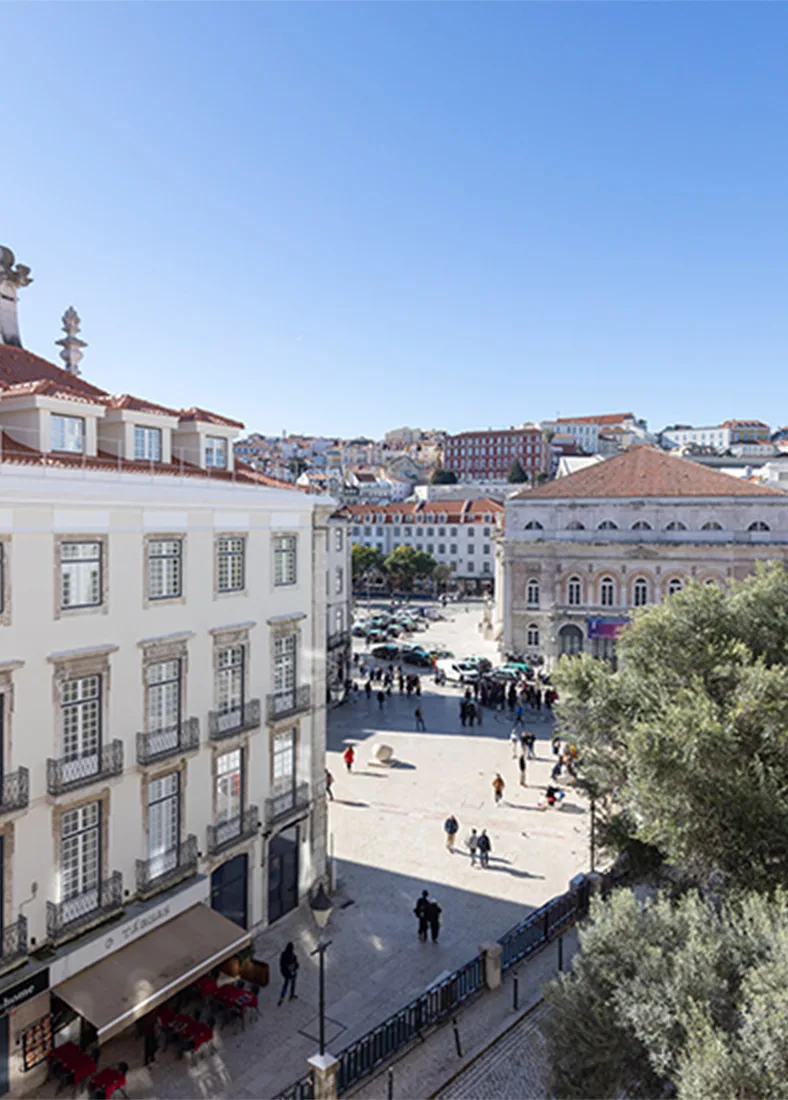 Espacio representativo del hotel: Una plaza soleada está rodeada de edificios históricos y mesas de café al aire libre.