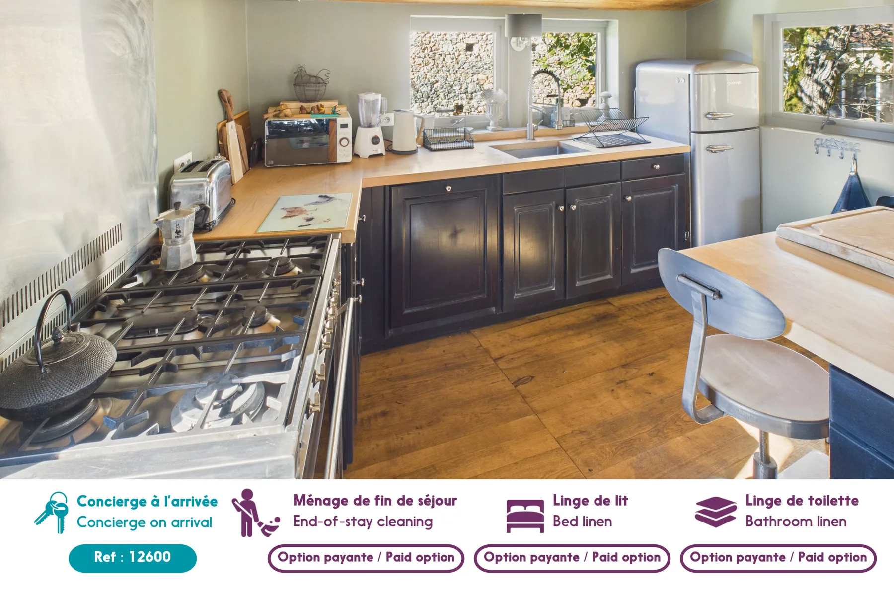 A kitchen with a long counter, sink, stove, and refrigerator.